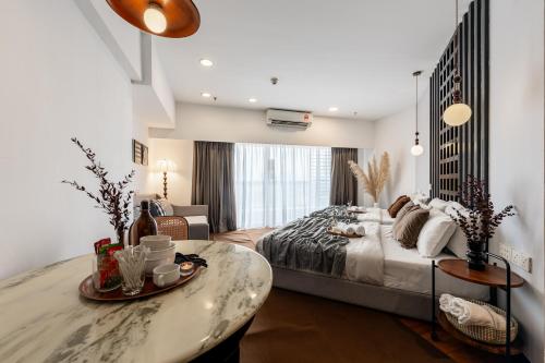 a bedroom with a large bed and a table at Resort Suites at Pyramid Tower by GL Staycation in Petaling Jaya