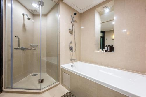 a bathroom with a shower and a tub and a sink at Resort Suites at Pyramid Tower by GL Staycation in Petaling Jaya