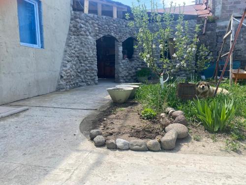 a garden in front of a house with a stone building at Robs in Gyumri