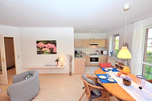 a kitchen and living room with a table and chairs at Atelier Gartenflair in Hohwacht