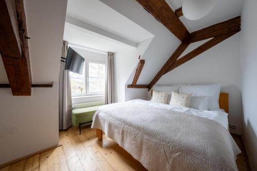 a bedroom with a white bed and a window at penzion Dvorce in Třeboň