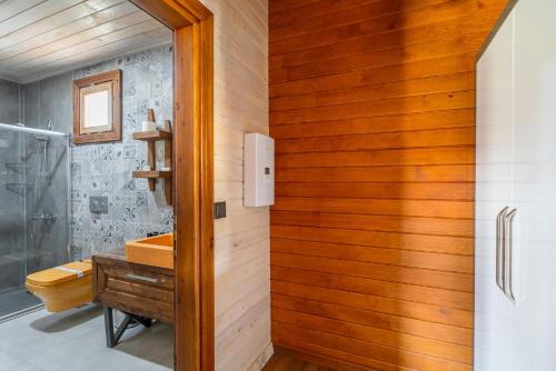 カーギジャックにあるSedir Park - Beach Bungalowの洗面台付きのバスルーム、木製の壁