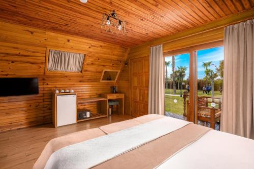 カーギジャックにあるSedir Park - Beach Bungalowのベッドと大きな窓のある寝室