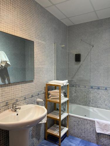 a bathroom with a sink and a bath tub at Apartamentos LLorca in Platja de l’Almadrava