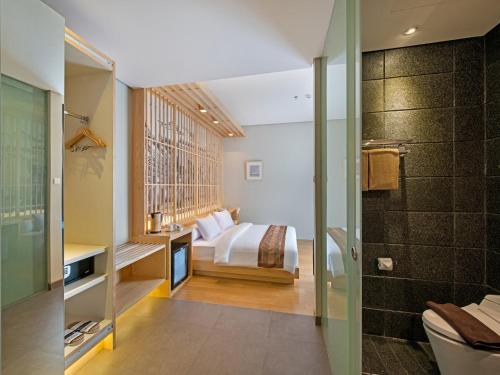 a master bedroom with a bed and a bathroom at Tama Boutique Hotel in Bandung