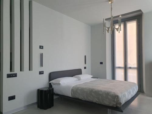 a white bedroom with a bed and a window at Cavallerizza flat in Brescia