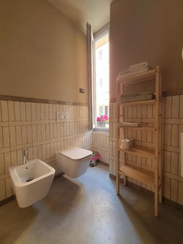 a bathroom with a toilet and a sink and a window at Cavallerizza flat in Brescia