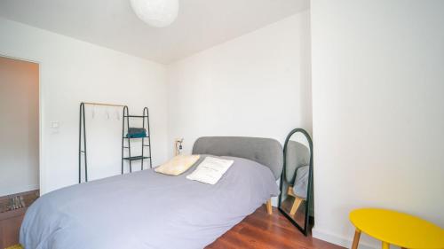 - une chambre avec un lit et une chaise jaune dans l'établissement Le ViewZen Duplex Asnières, à Asnières-sur-Seine