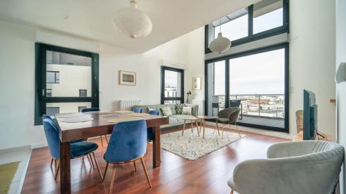 un salon avec une table et des chaises de salle à manger dans l'établissement Le ViewZen Duplex Asnières, à Asnières-sur-Seine