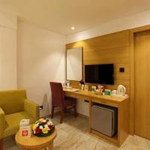 a hotel room with a desk and a couch at Park Residency Kodungallur in Trichūr