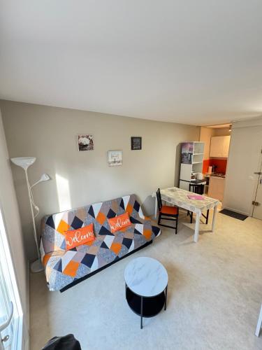 un salon avec un canapé et une table dans l'établissement Le Champenois, plage et calme, à Merville-Franceville-Plage