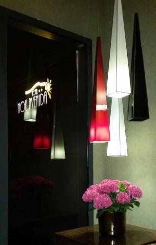 a vase of pink flowers on a table with lights at Nou Avenida in Gata de Gorgos