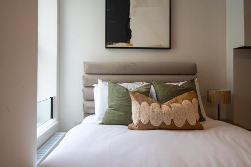 a bedroom with a white bed with green pillows at VESTO Stays Brighton in Brighton & Hove