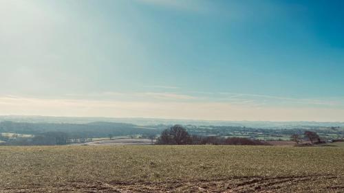 a grassy hill with a view of a field at Lake House - beautiful countryside retreat in Clutton