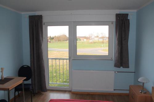 a room with a large window and a table and a desk at Hotel Birten in Xanten