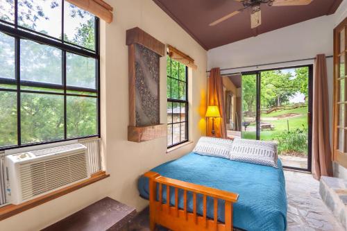 a bedroom with a bed in a room with windows at Pecan Creek Cottage in Fourth Crossing
