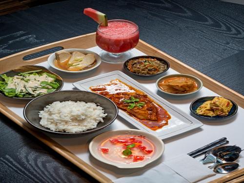 a tray of food with rice and a drink at Tama Boutique Hotel in Bandung