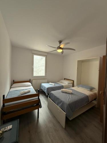 ein Schlafzimmer mit zwei Betten und einem Deckenventilator in der Unterkunft Amplio piso para 17 en pleno centro de Madrid in Madrid