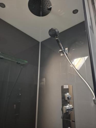 a shower head in a bathroom with a mirror at Perfect Gites In Normandy - New Beginnings Barn in Saint-Sauveur-de-Chaulieu
