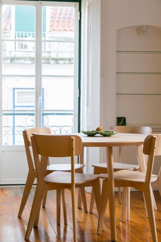 a dining room table and chairs with a window at Spacious, Bright and Newly Renovated 2 Bedroom Apartment, Lisbon Historical Center, Madragoa in Lisbon