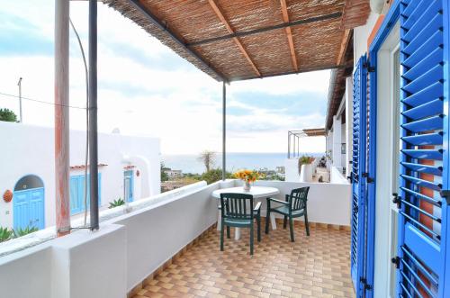 a balcony with a table and chairs and the ocean at Residence Limoneto Ischia in Ischia