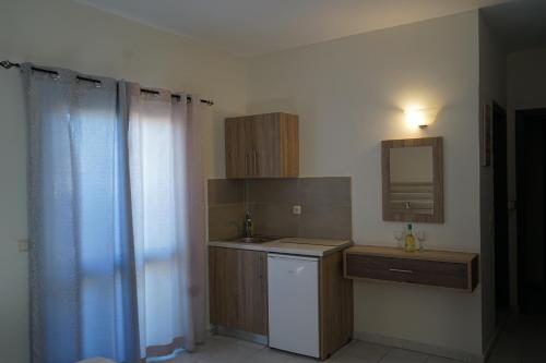 a small kitchen with a sink and a mirror at ROMANTZA apartments in Agia Marina Nea Kydonias