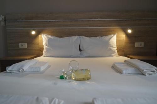 a white bed with two towels and a purse on it at ROMANTZA apartments in Agia Marina Nea Kydonias