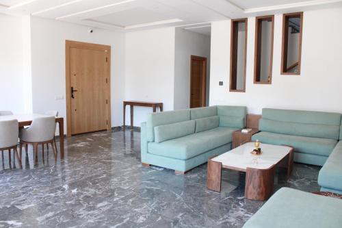 a living room with two blue couches and a table at Villa Bakhta in Najem