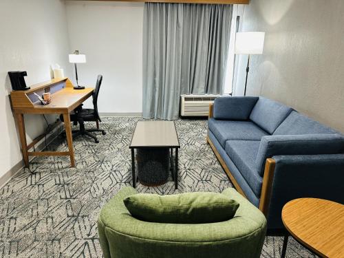 a living room with a blue couch and a desk at Country Inn & Suites by Radisson, Canton near Hall of Fame in Canton