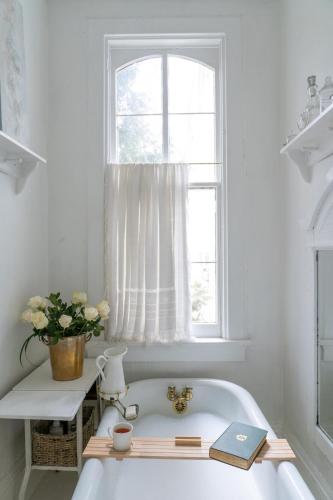 a bath tub in a bathroom with a window at Church Des Artistes in Kingston