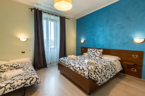 a bedroom with two beds and a blue wall at Palazzo Santori in Tivoli
