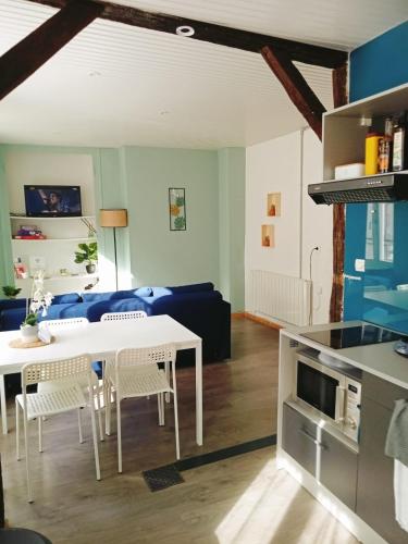 a kitchen and living room with a white table and chairs at Le petit refuge de Venose in La Châtre