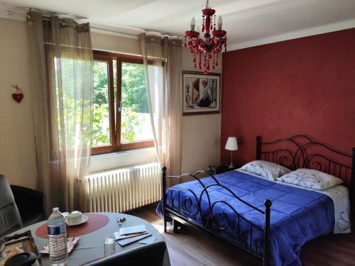 a bedroom with a blue bed and a red wall at Colmar "Room" chambre privée chez l'habitant,parking voiture devant la maison,garage moto et vélo,petit déjeuner in Colmar