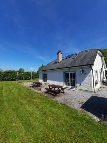 a white building with a picnic table in front of it at Clone manor Lodge in Ballyragget
