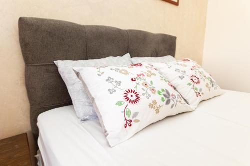 a bed with three pillows on top of it at Ugi house - City Center in Belgrade