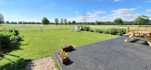 a patio with a picnic table and a field at Camping KiekeBoe in Maria-Hoop