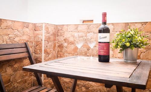 a bottle of wine sitting on a wooden table with glasses at Casa Thula - Hello Vejer in Vejer de la Frontera
