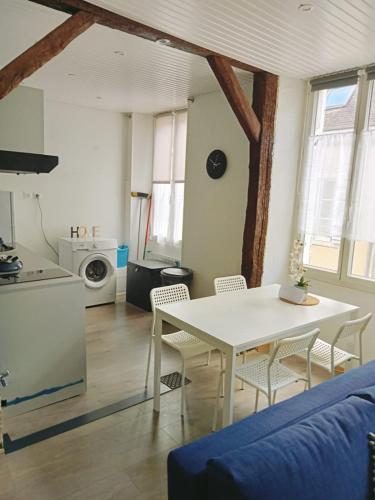 un salon avec une table et des chaises blanches dans l'établissement Le petit refuge de Venose, à La Châtre