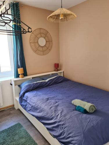 a bedroom with a bed with a blue comforter at Le petit refuge de Venose in La Châtre