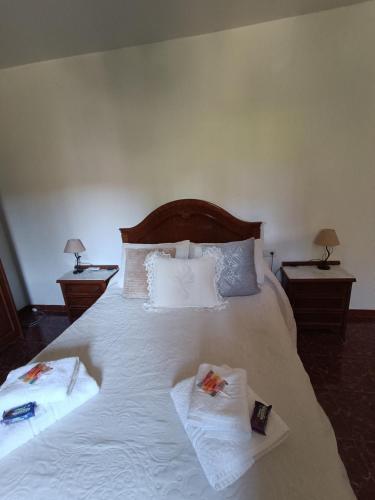 a bedroom with a large white bed with two tables at Casa Rural Chalet Venta del Aire Cortijo Terron in Lanjarón
