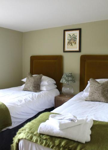two beds sitting next to each other in a room at The Peacock at Barlow in Chesterfield