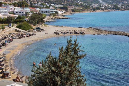 a beach with umbrellas and people in the water at Sunrise Hotel in Pefki Rhodes