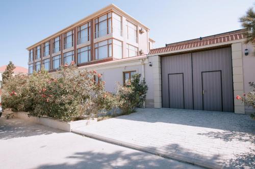 a house with a garage and some bushes at Sabah hotel Buzovna Baku in Buzovna