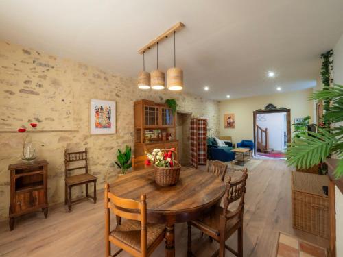 un salon avec une table et des chaises en bois dans l'établissement Charming House In The Heart Of Dordogne, à Monpazier