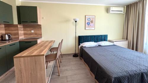 a hotel room with a bed and a desk and a kitchen at Evi Apartments 2 in Pomorie