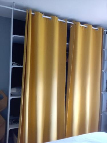 - deux rideaux jaunes dans la chambre dans l'établissement Chambre meublé chez habitant, à Roézé-sur-Sarthe