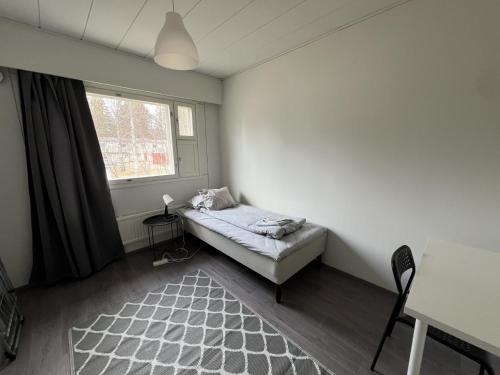 a small bedroom with a bed and a window at Puomitie for 3 persons in Kajaani