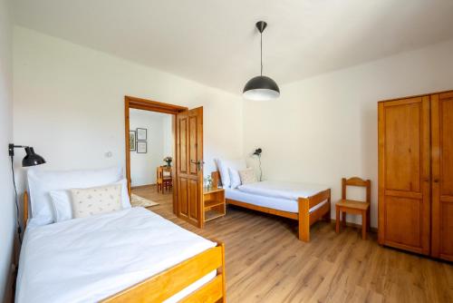 a bedroom with two beds and a table and chair at penzion Dvorce in Třeboň