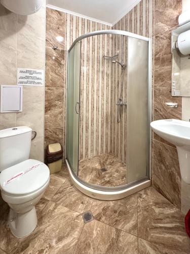 a bathroom with a shower and a toilet and a sink at Evi Apartments 2 in Pomorie