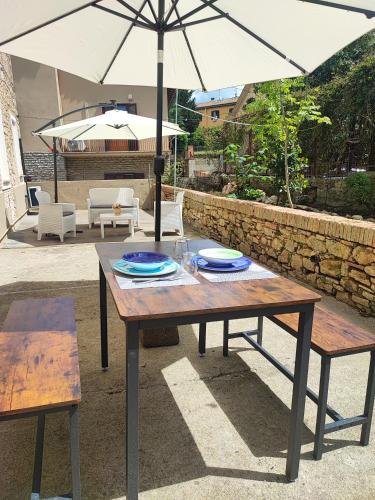 a wooden table with an umbrella on a patio at La casina nel borgo in Volterra